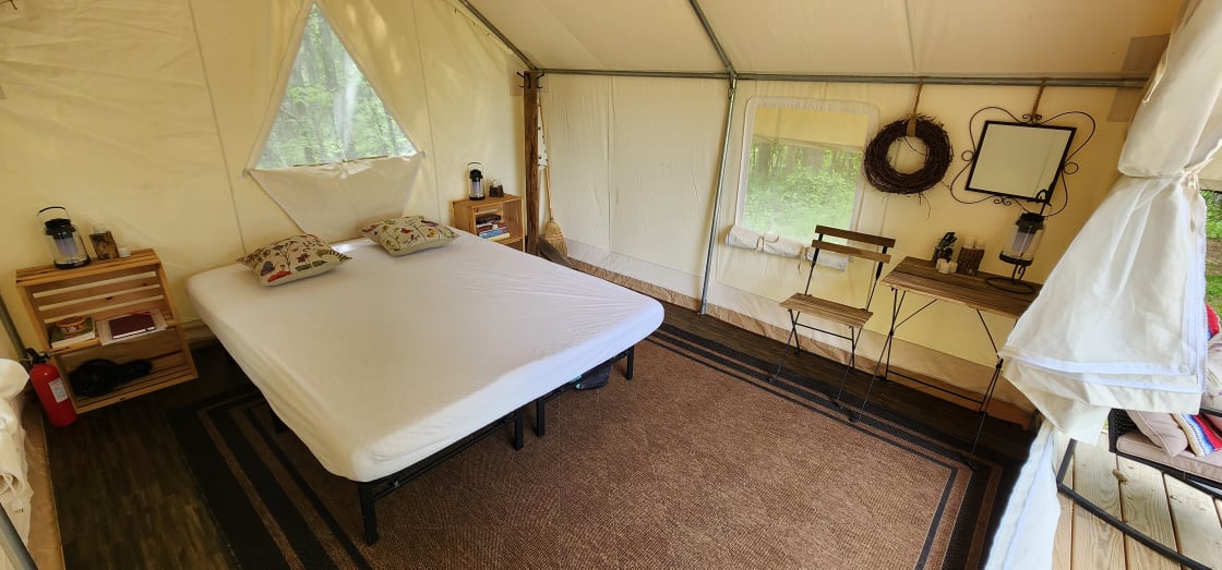 Inside of platform tent has a queen size bed, table & chairs, side tables with games, and a coat rack. In colder months we also have a propane heater.