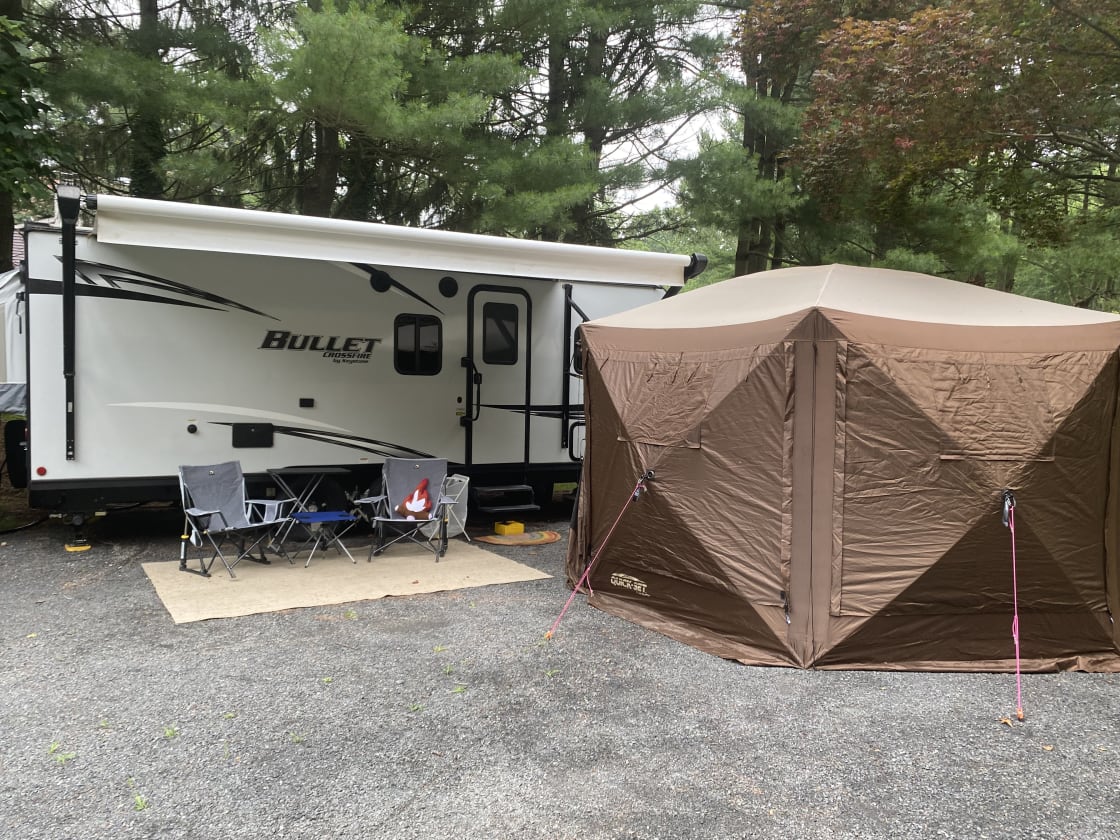 The Rusty Goat (our 2021 Bullet Crossfire) on our personal property next to our home. Optional Clamshell Tent for Luggage & Changing OR dining.