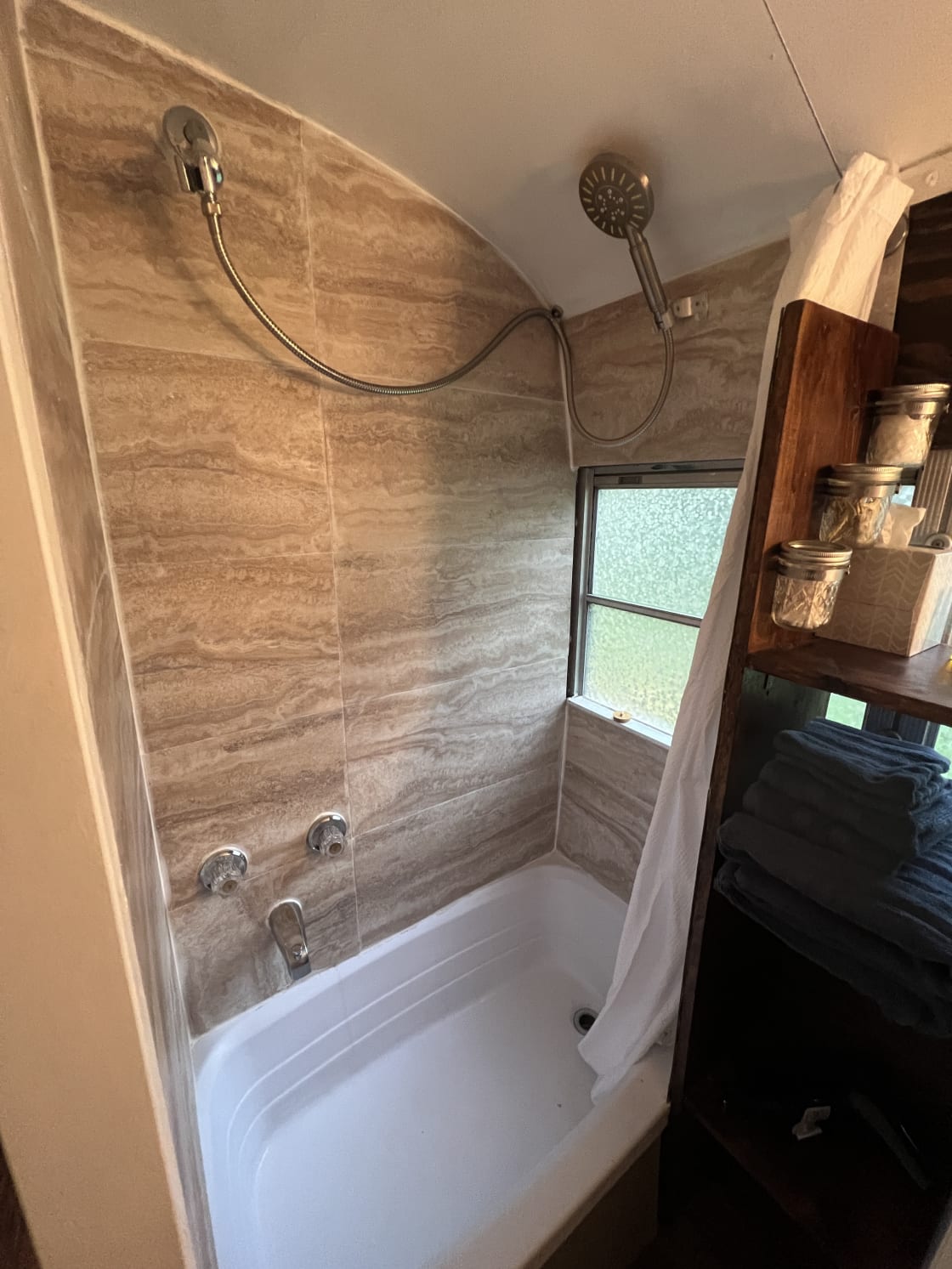 Tiny bathtub and shower with on demand  hot water. 