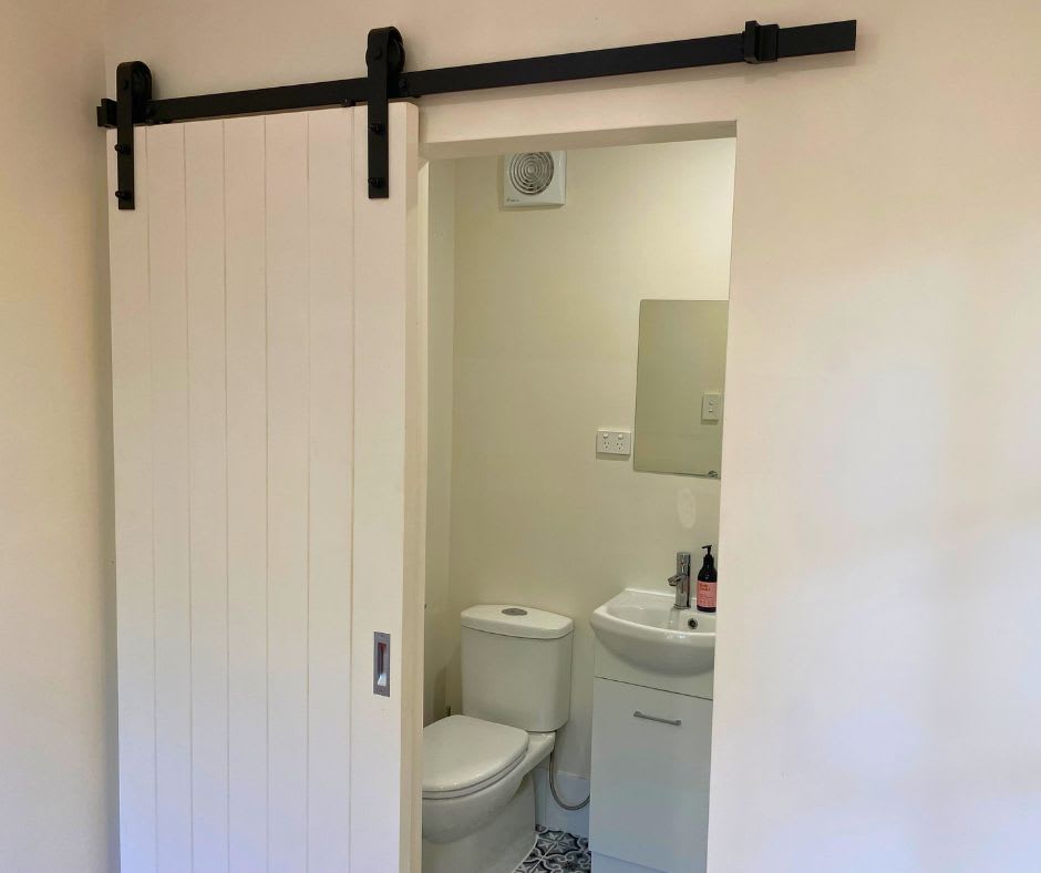 Private ensuite bathroom with hot shower, vanity and flushing toilet.