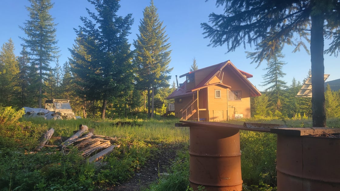 View of the back of the cabin from the fire pit with the sunrise shining on the cabin.