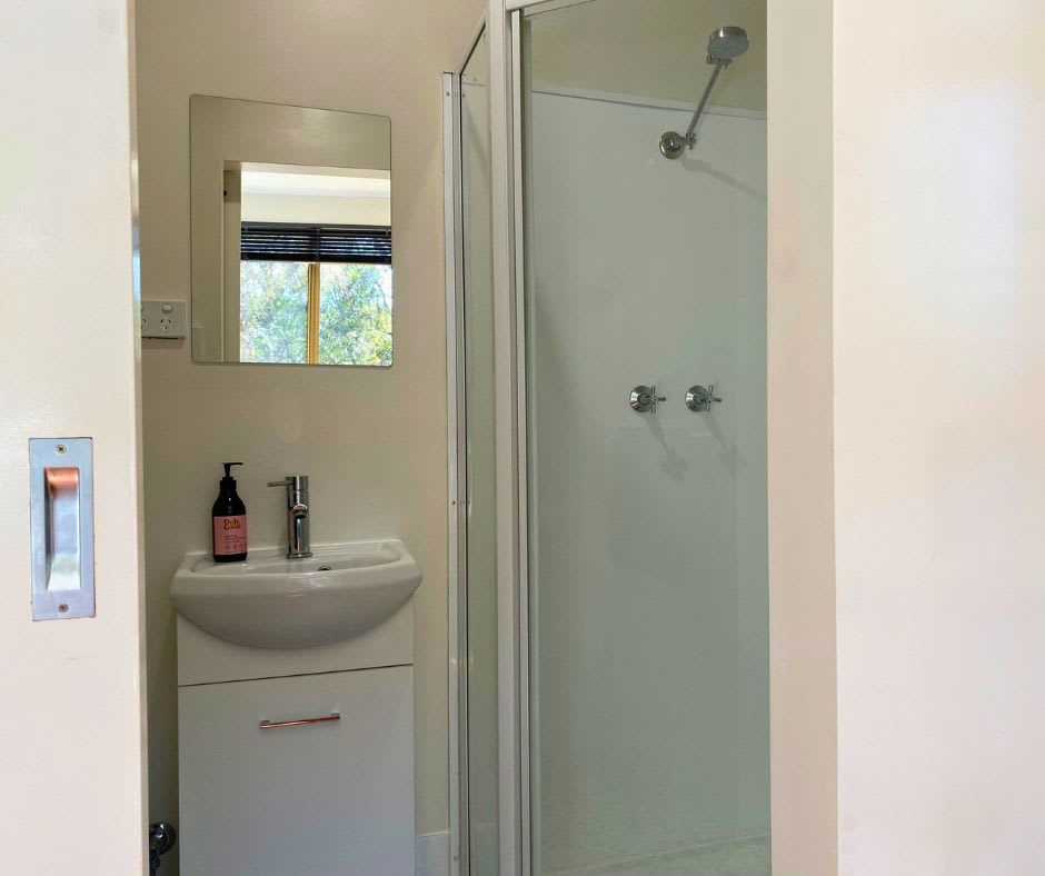 Private ensuite bathroom with hot shower, vanity and flushing toilet.