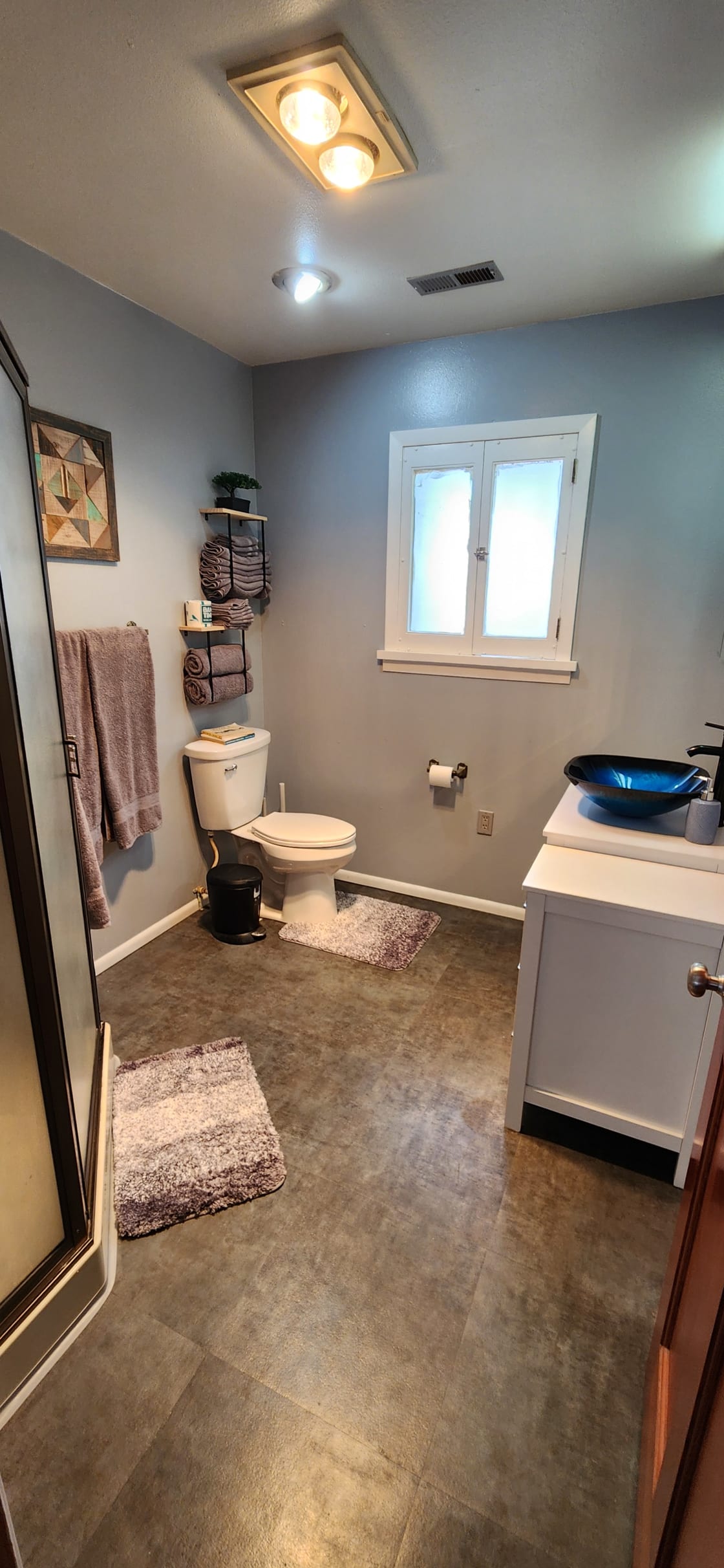 Nicely Remodeled bathroom with a toilet, sink, and a hot water shower.