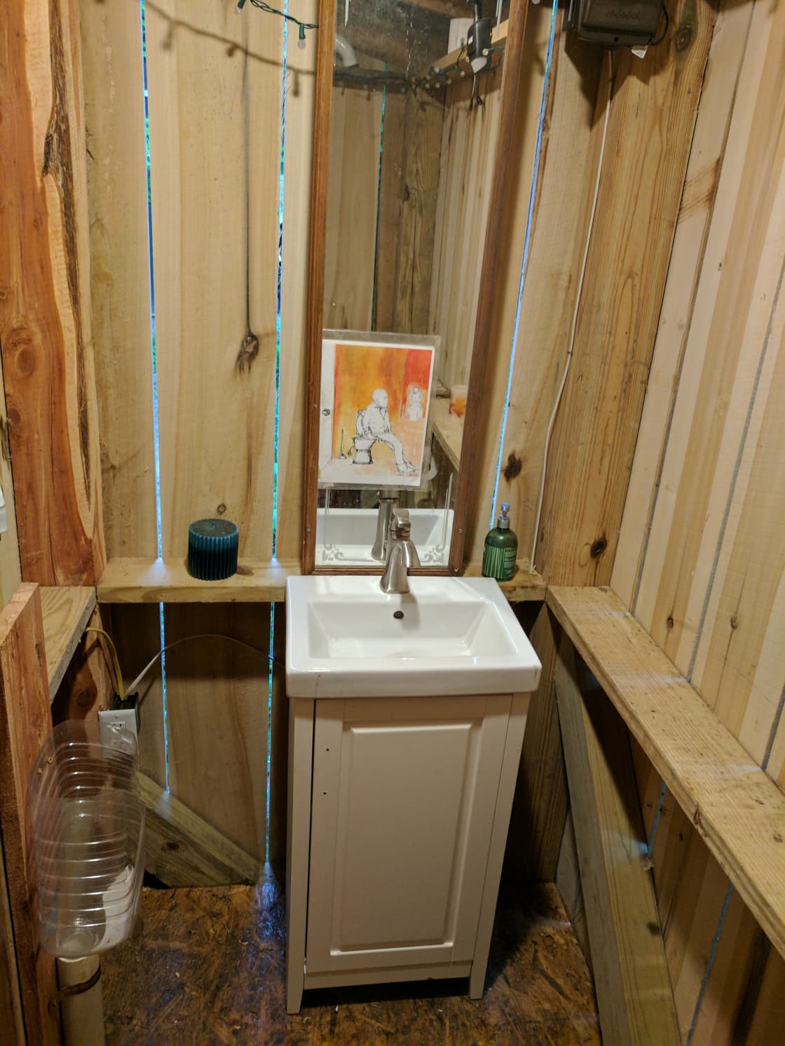 Outhouse has a sink and a custom urinal (water bottle on left). It was made out of all scrap materials and lumber that we milled off our own land. 