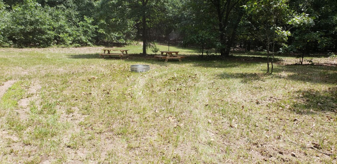 Picnic tables and firepit provided at campsite.