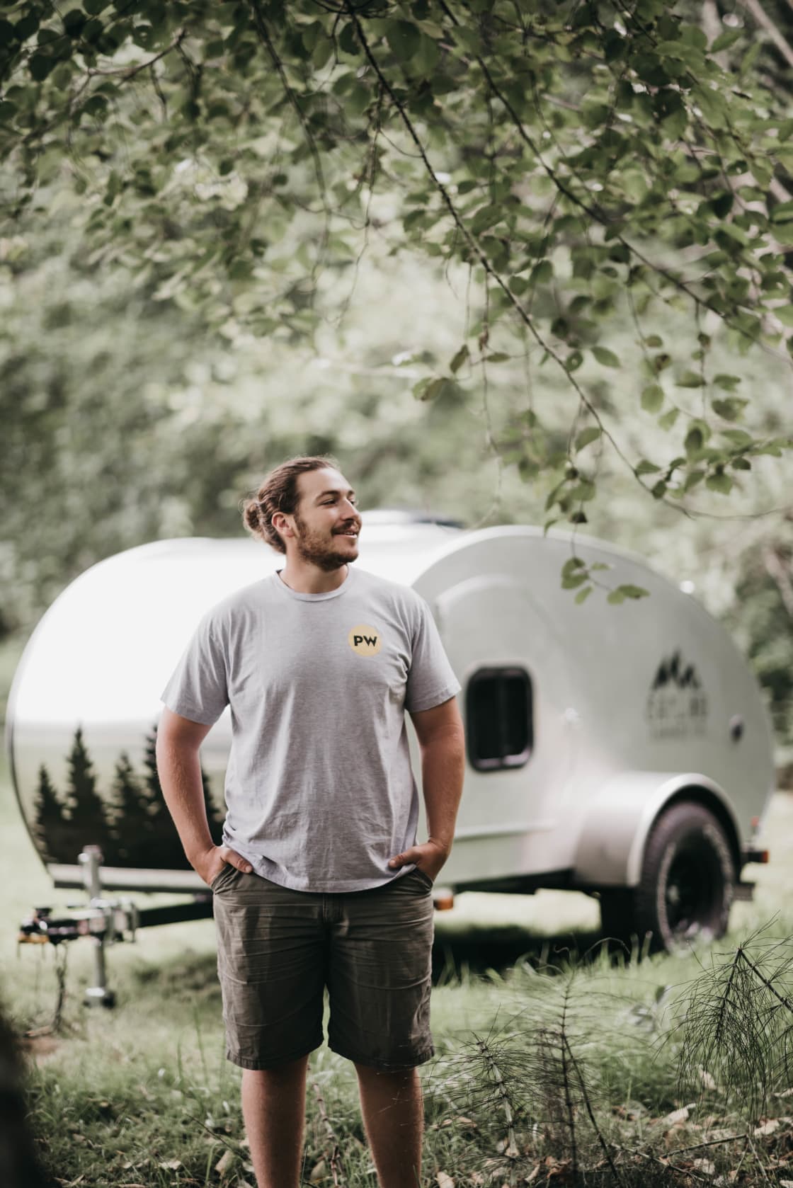 Nick posing in front of our awesome handcrafted teardrop, glad that we're taking the time to adventure with it and ready for a beer after a stressful day of campground hunting! 