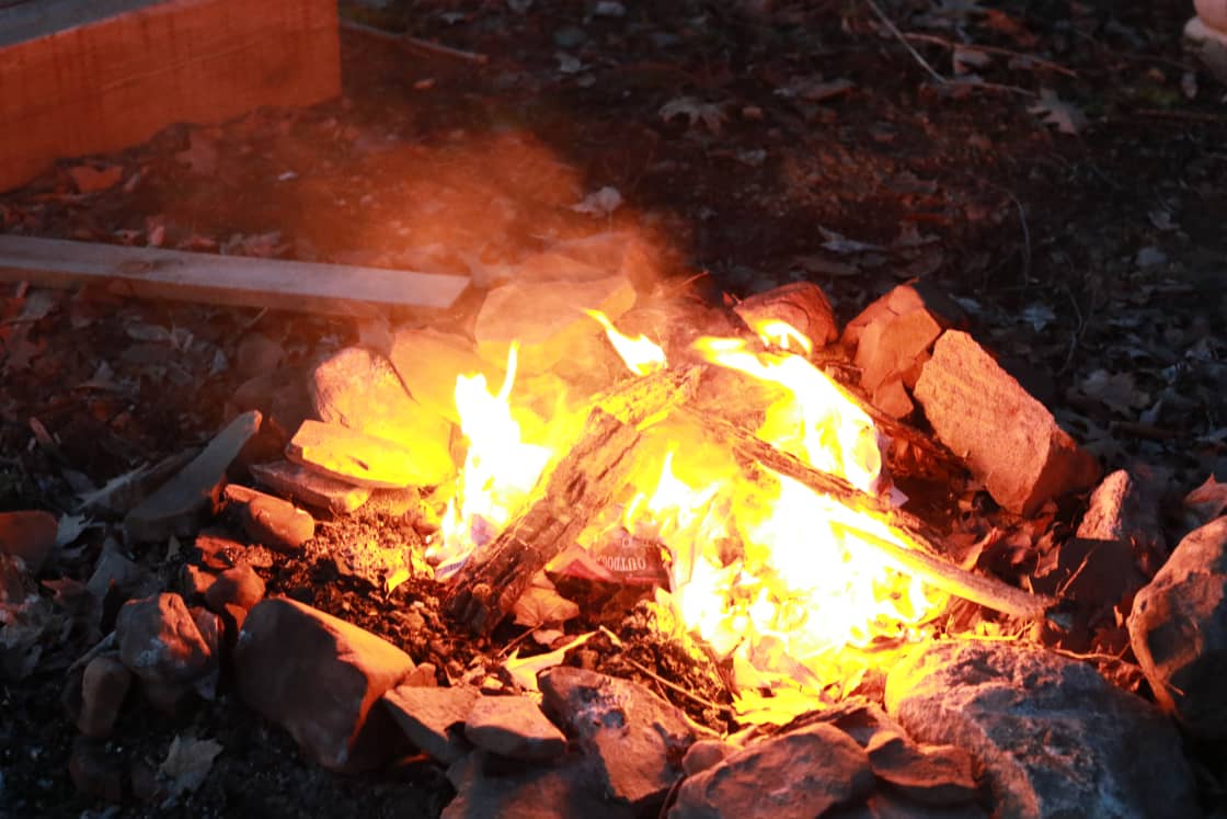 Enjoy a small, mellow fire in the quiet and dark wooded night.