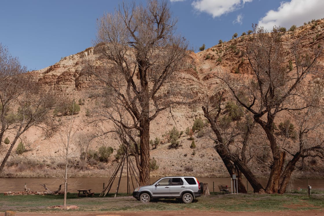 RV spots are right along the river with the huge colorful canyon backdrop rising behind them. 