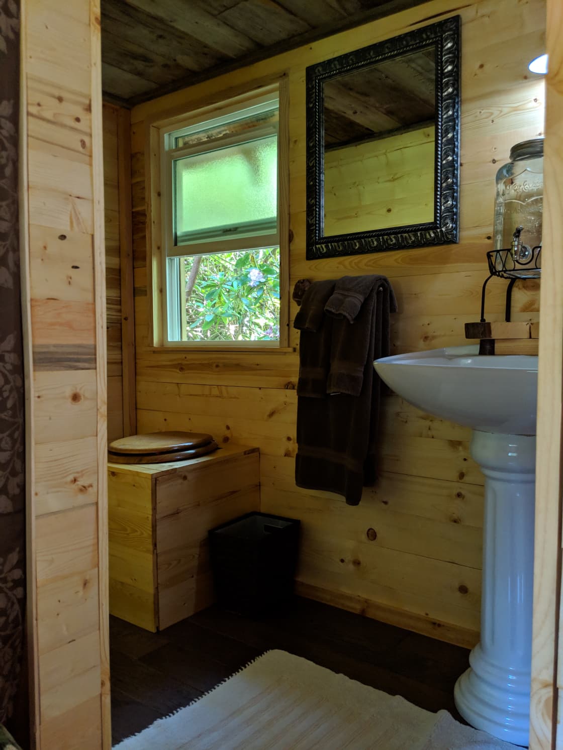 Off grid with compostable wood chips toilet and cistern fed sink with filtered spring water for drinking and washing.