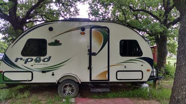 R pod camper situated under old oak trees.