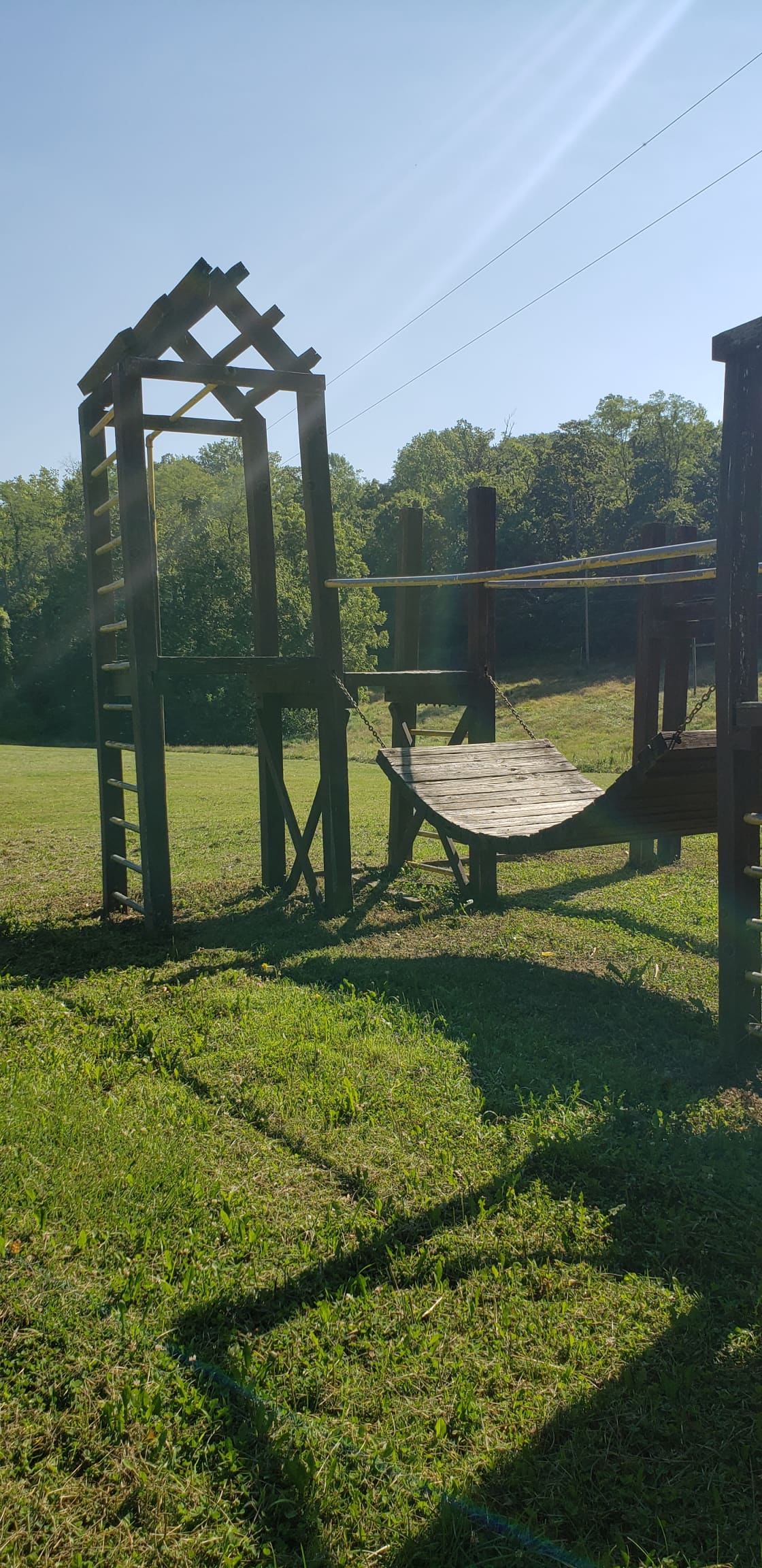 Play structure with bridge, swings and slide.
