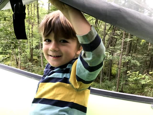 Into tent with grandson and able to see the tree canopy behind him