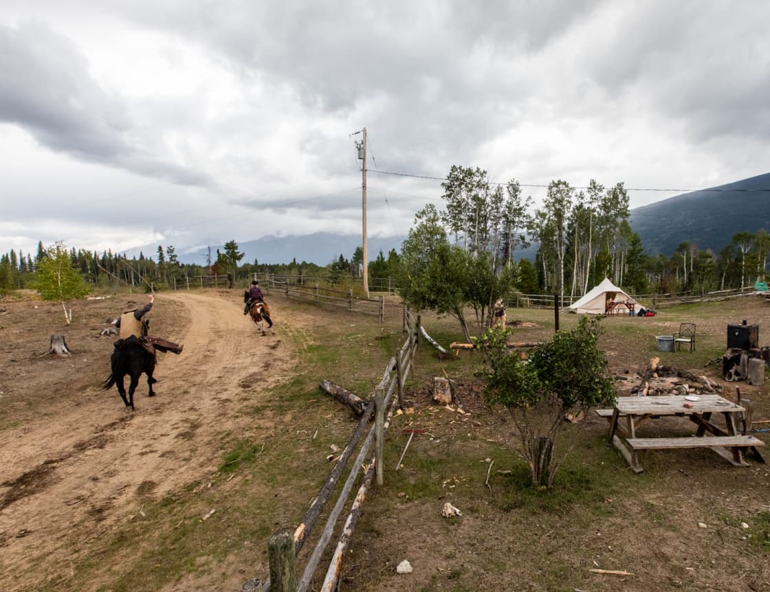 Gavin & Jaime-Lee taking their horses out for a spin around the property. Large firepit just on the right, tent in the background and shower hut as well.