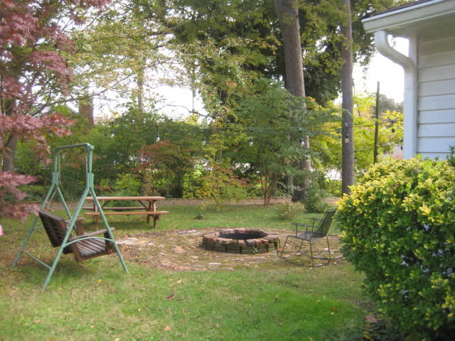 Fire pit with picnic table, swing and chairs.