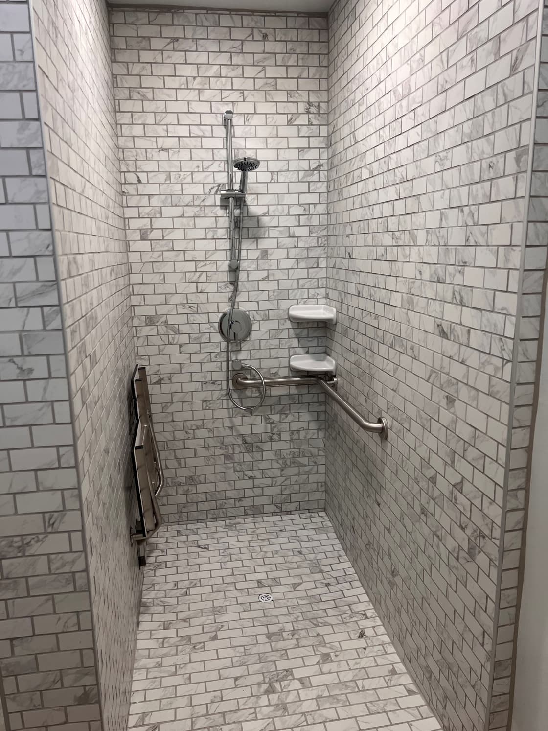 White marble-tiled individual bathrooms that are also ADA compliant.