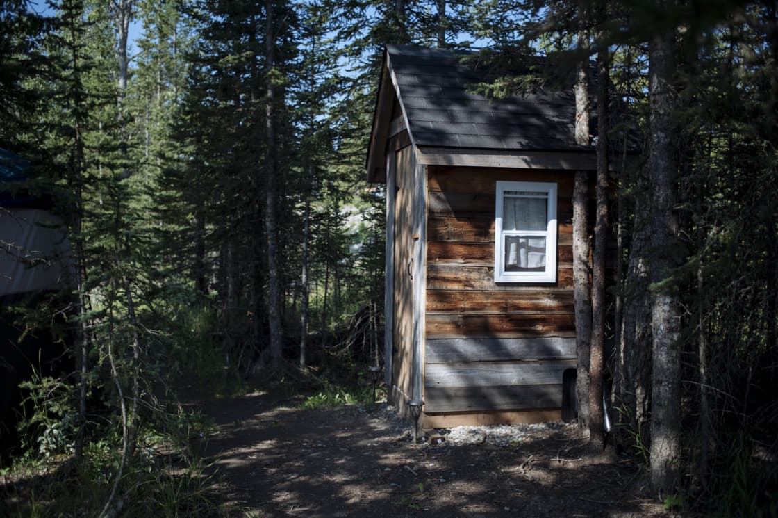 Cute little log outhouse is steps from the tent