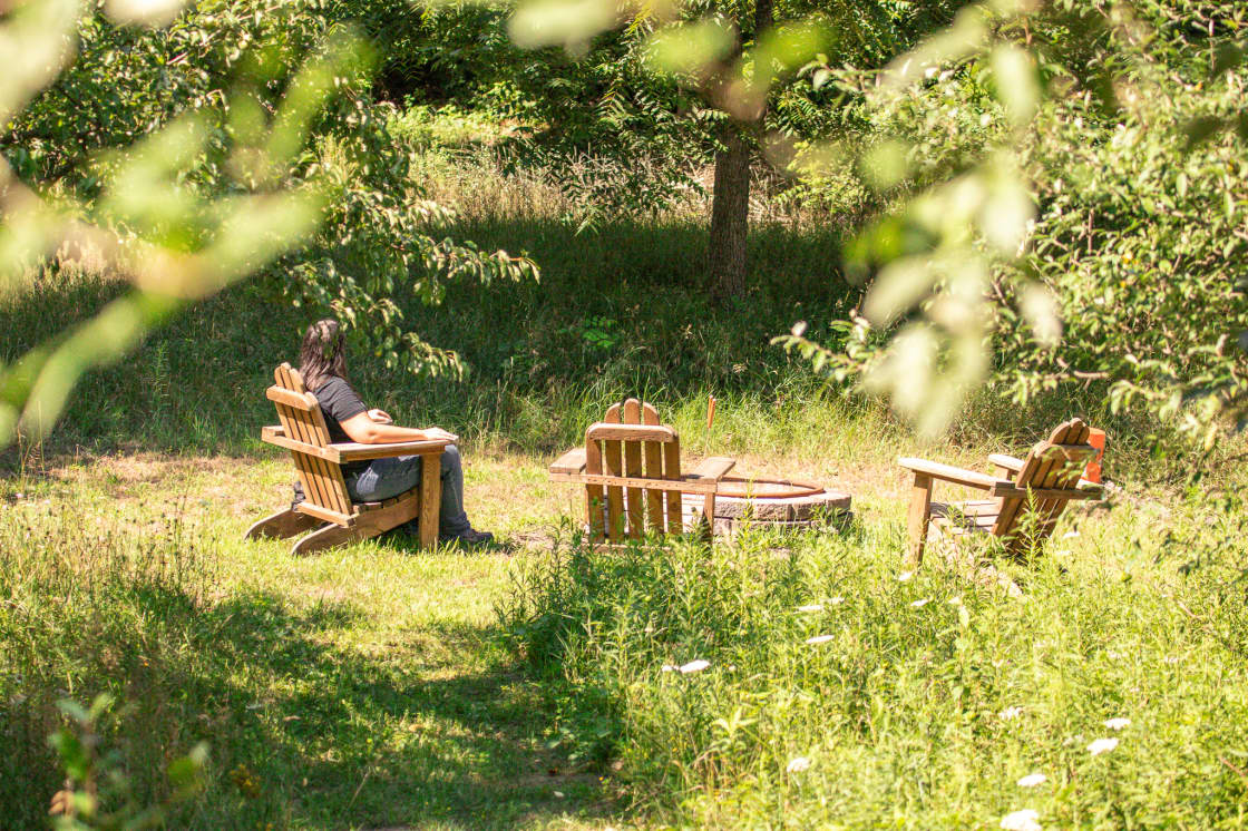 There is a large firepit area with chairs and provided firewood.