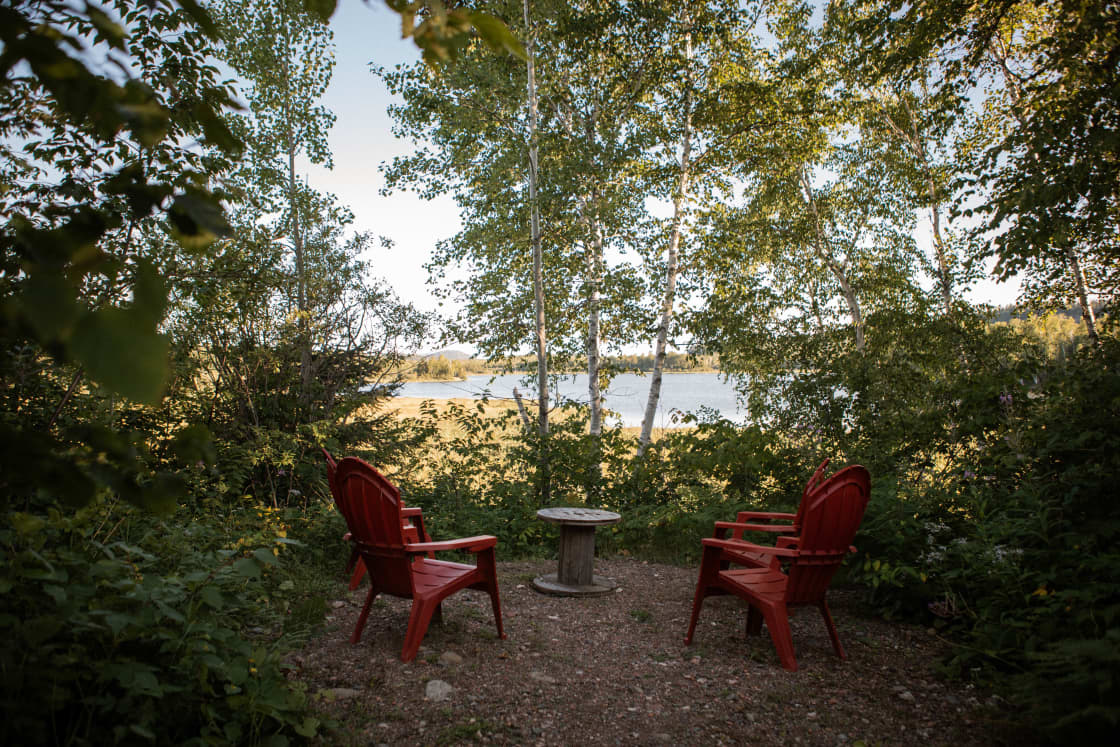The campground has a two look out areas with four chairs and a table over looking a lake.
