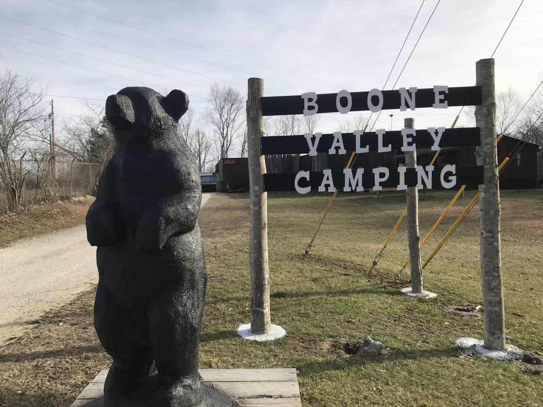 Sign and black bear statue next to the highway at the turn into the campground.