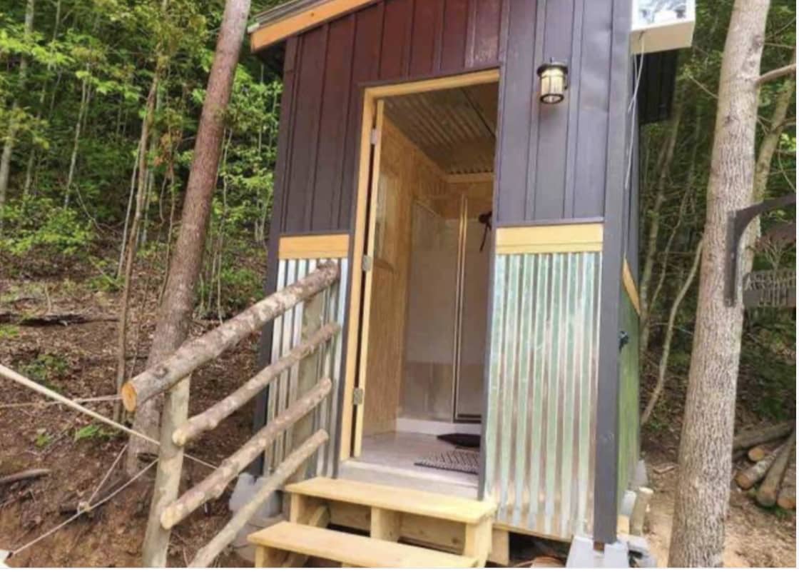 private bathhouse with hot shower, flushing toilet, and vanity