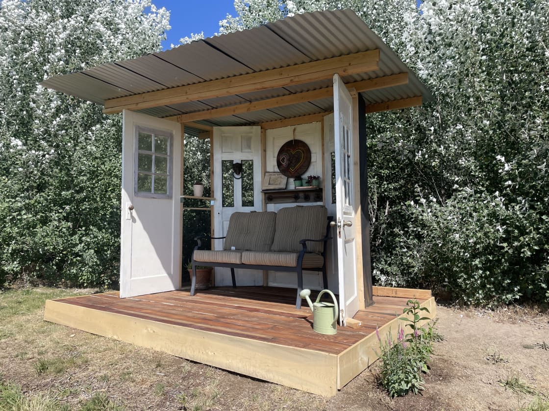 New standalone patio made primarily from reclaimed wood as well as doors and windows from 80-100yr old houses from Boise's North End provides a new place to sit and enjoy the view and the wildflowers