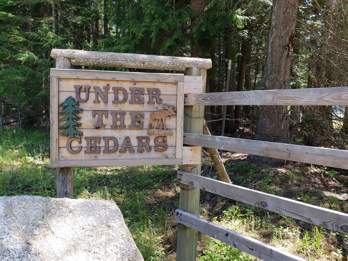 Under The Cedars sign at the gate