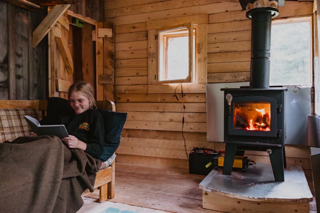 The newest addition to the cabin is a sunroom featuring a wood stove for cooking or chilly evenings and a couch for lounging.