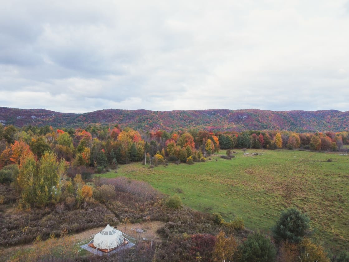 Stargazer tent from above, overlooking the fall colours of the Eardley Escarpment.