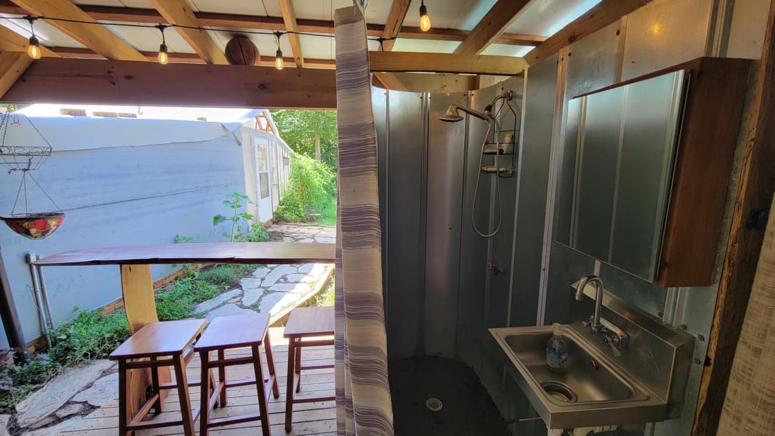 The outdoor shower on the right, and a sitting area overlooking the garden on the left. 