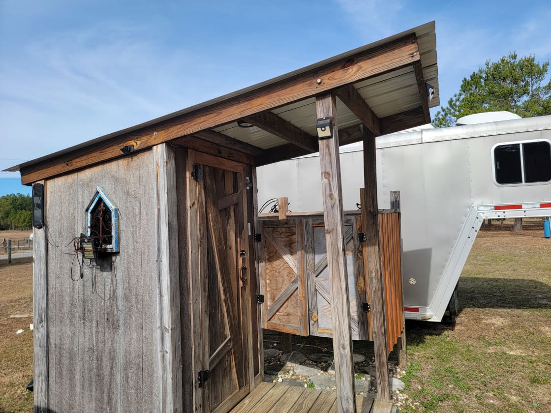 Outhouse & large shower.  That's a horse trailer parked beside it, not a camper - no prying eyes!