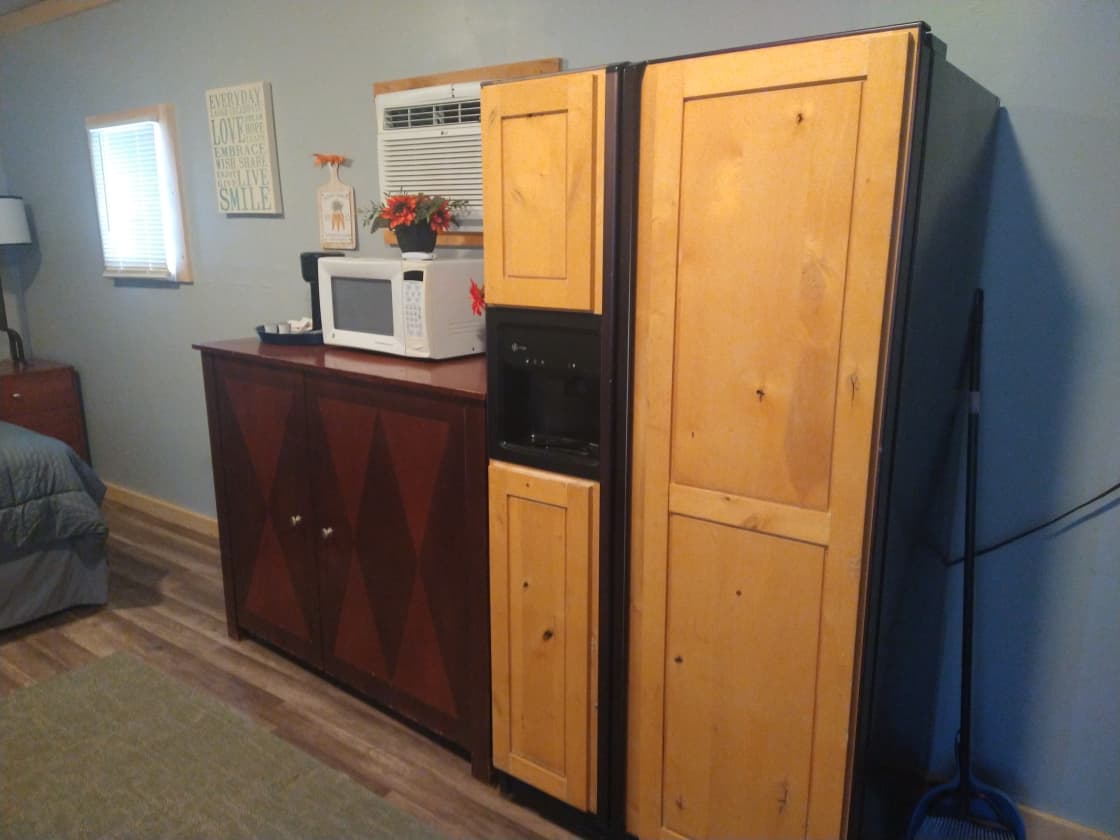 Fridge, microwave, cabinets, food preparation area.