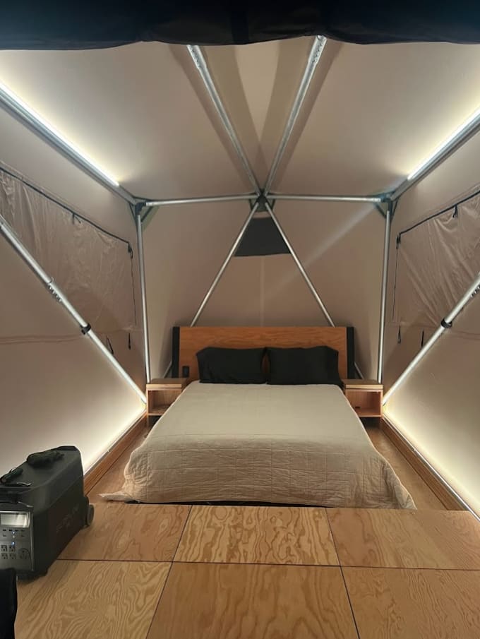 Interior of tent. Storage is available in 3 of the floor compartments. Additional battery (pictured) is not included. Solar panels power battery integrated with the tent. 