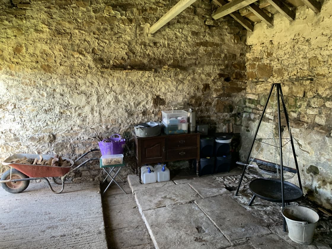 Inside the cow byre HQ: Where you'll find bins, firewood, potable water, and various accessories. Bikes and camping kit may also be stored in here.