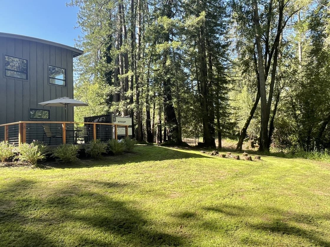 View from the forest.  The building to the left is a garage currently  used only for storage and won't be accessed by owners while you are on the property.