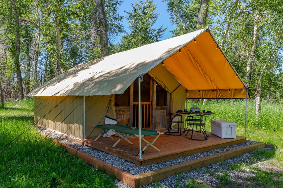 Tent porch includes bear-proof cooler, dining table, seating for four diners & a cot perfect for outdoor naps listening to the birdsong.