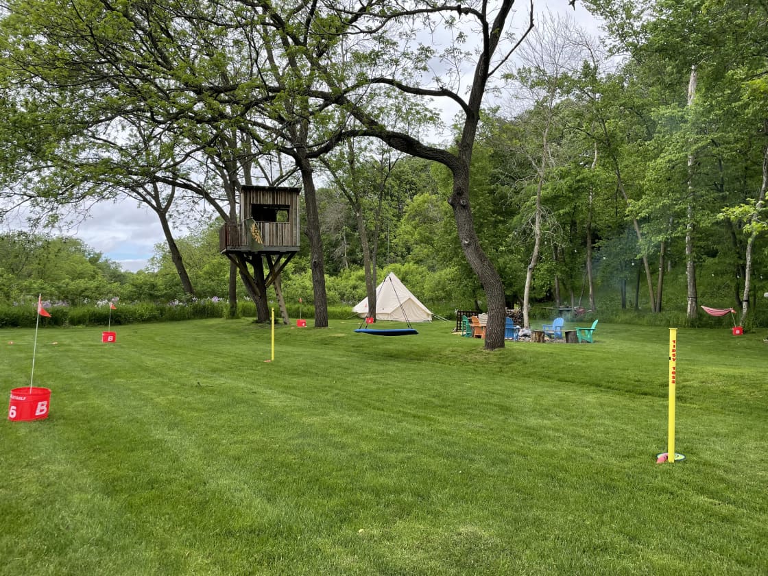 View of property with yard games and tree swing.