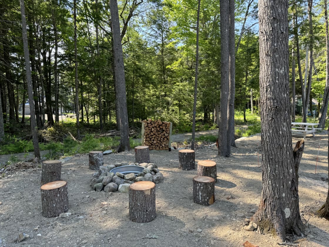 Fire pit with 8 stump seats.  Firewood included - see fire wood rack in middle of picture.
