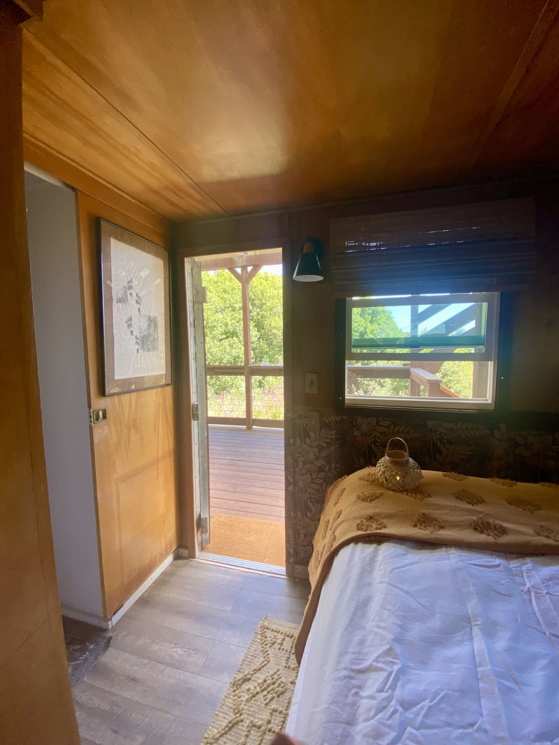 Pretty views and a golden light past the shady deck from the bedroom 