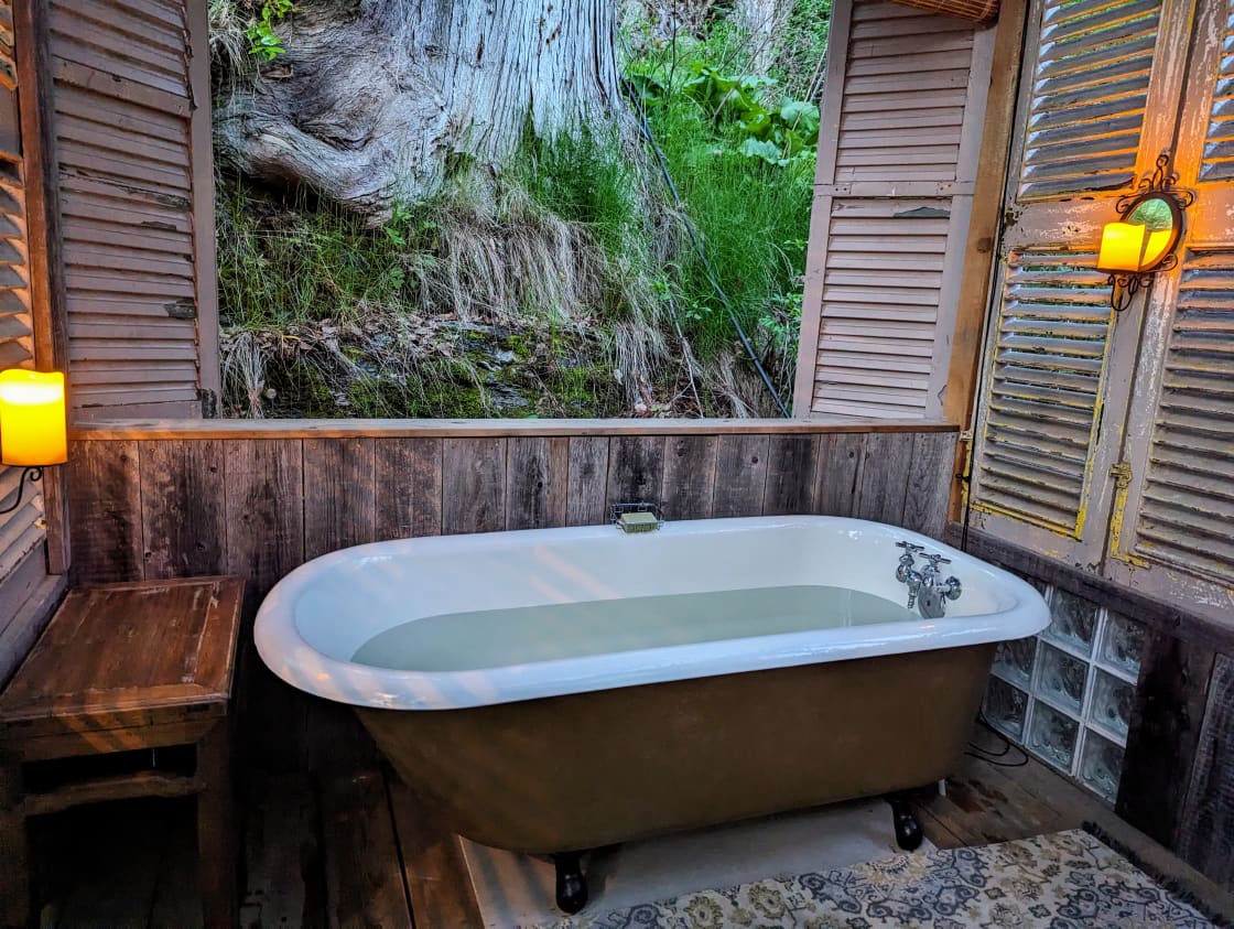 Soak in this this 100-year-old cast iron fully refurbished tub by candlelight beside a giant cedar.