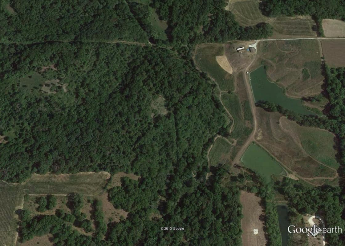 This is the google earth view of the 30 acres - on the right 1/3 of the picture.  You see the farm road in the upper right hand corner, leading to the rock driveway, garage and cabin.  The RV parking is available on the north side of the cabin, or on the rock driveway in the front of the garage for the big RV's.  Smaller RVs/vans and tent camping could park anywhere except the crop and prairie grass fields during dry months.  
