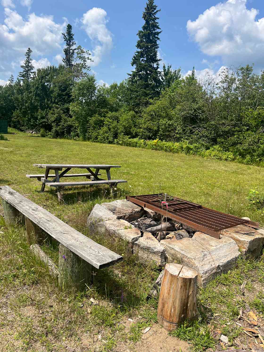 Large firepit and cooking grate available for campers to use.
