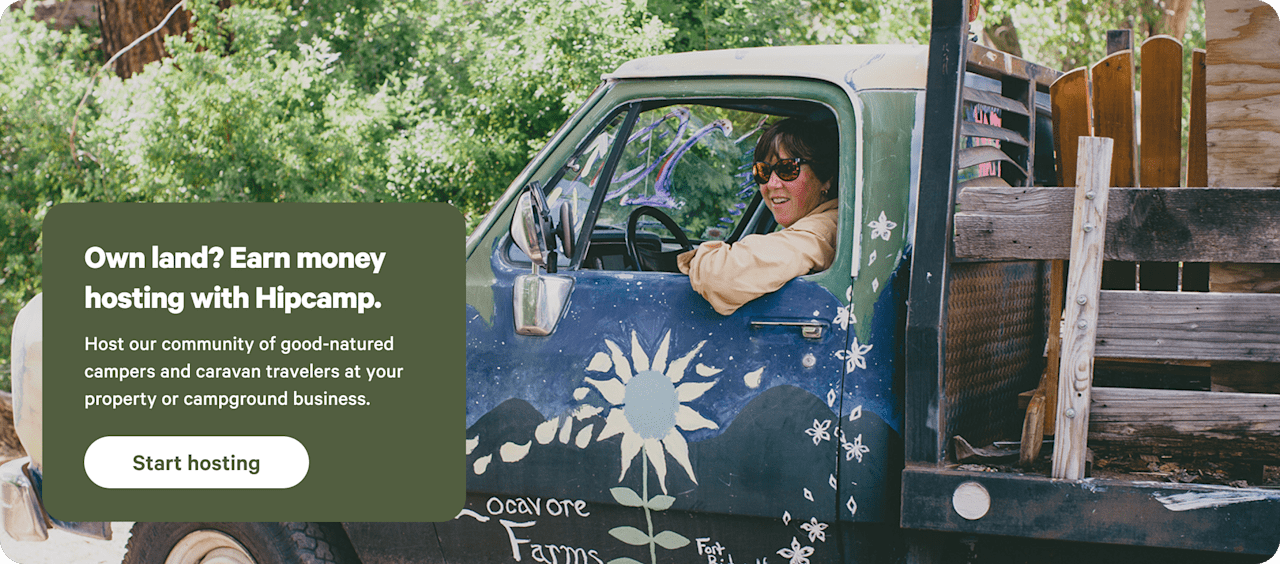 Happy farmer sitting in a truck in a grassy field