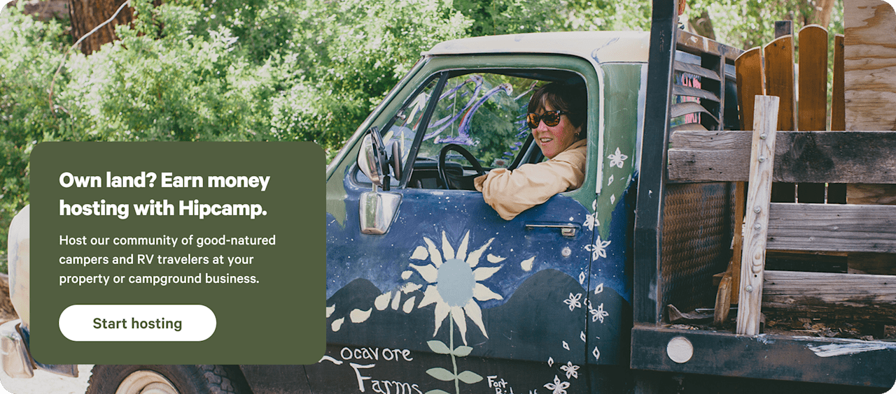 Happy farmer sitting in a truck in a grassy field