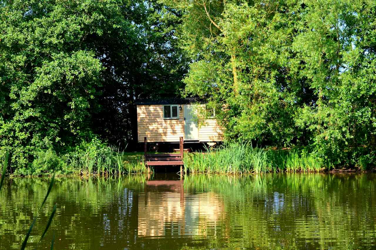 A waterside shepherd's hut at Purple Badger Camping in Leicestershire.