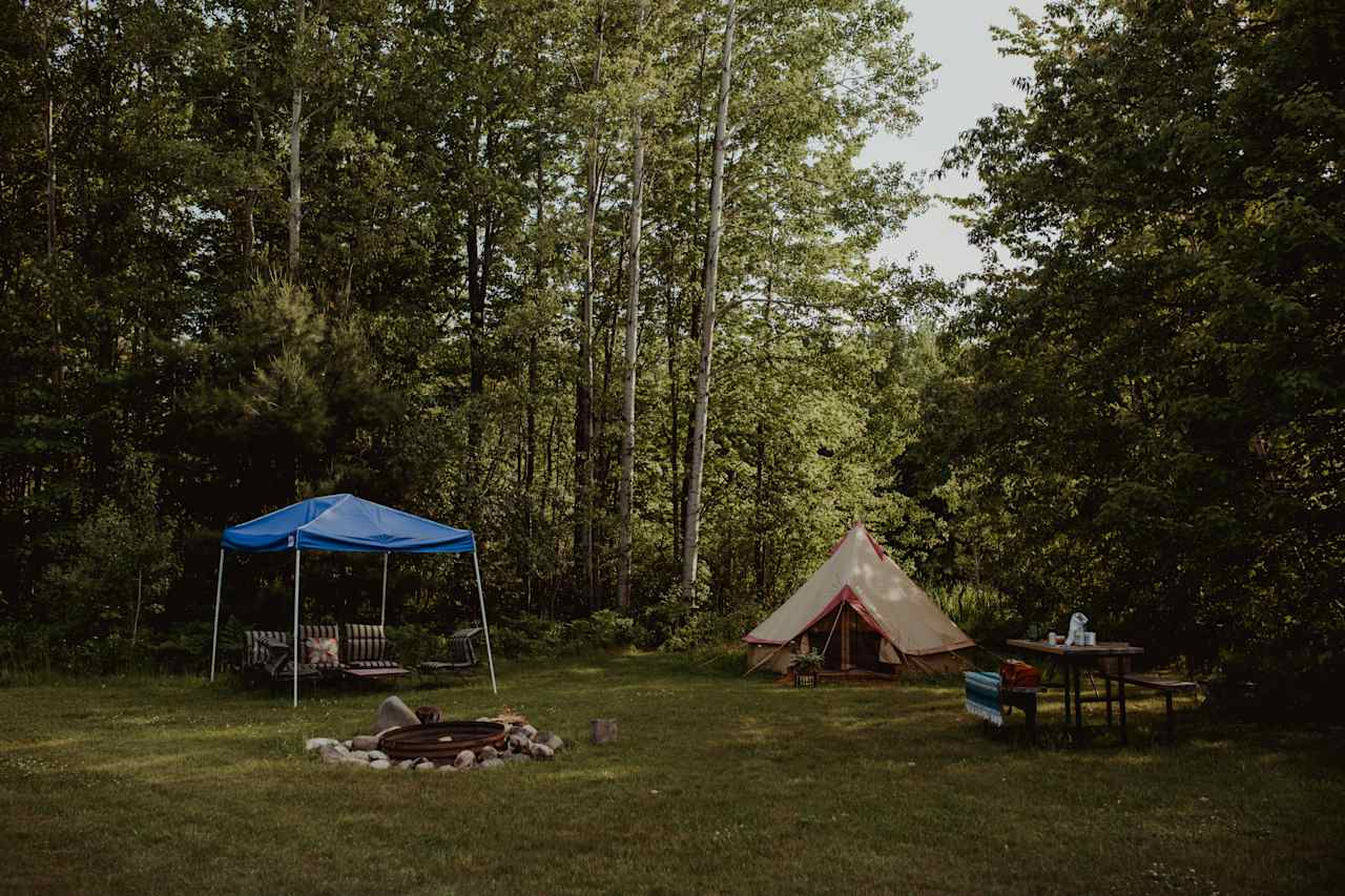 The full tent campsite, including table, firepit, and sitting area.