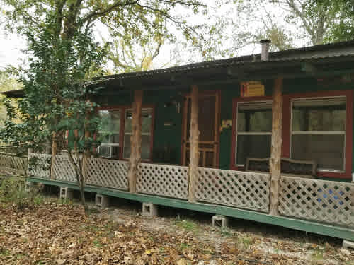 Mallard Haven CABIN-HOUSE, front porch.  The location is next to a large pond, just inside the entrance to the property.