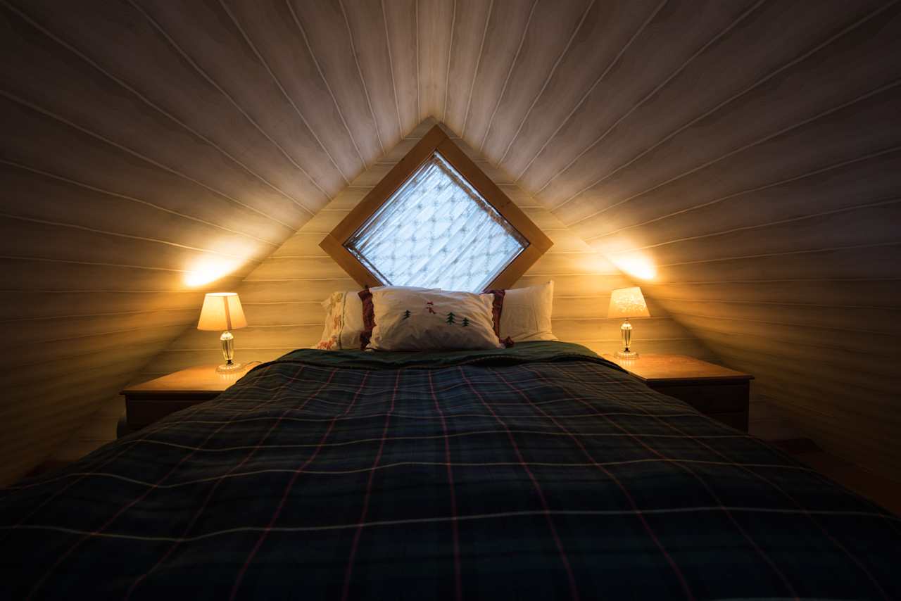 The bed in the loft above the kitchen.