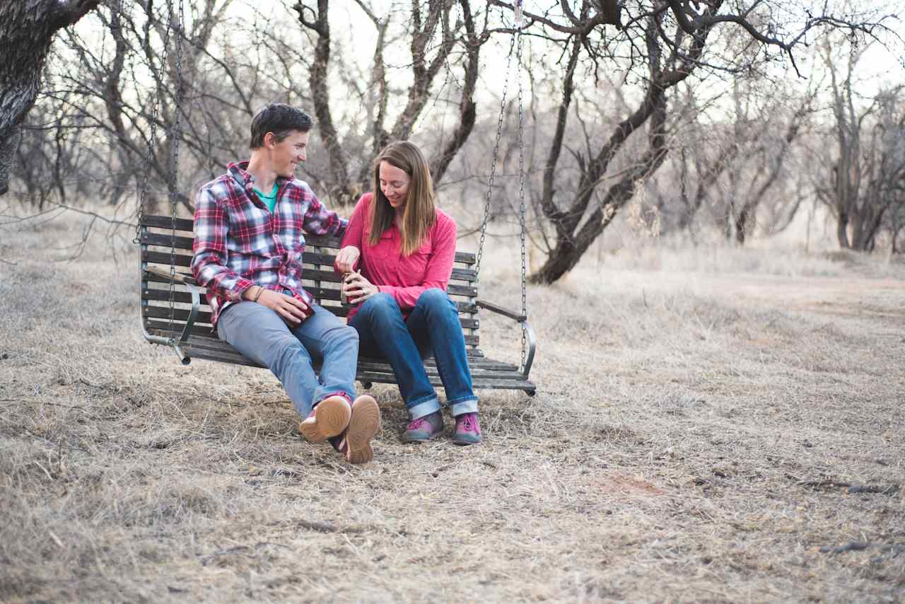 A porch swing hangs from a sturdy mesquite branch.