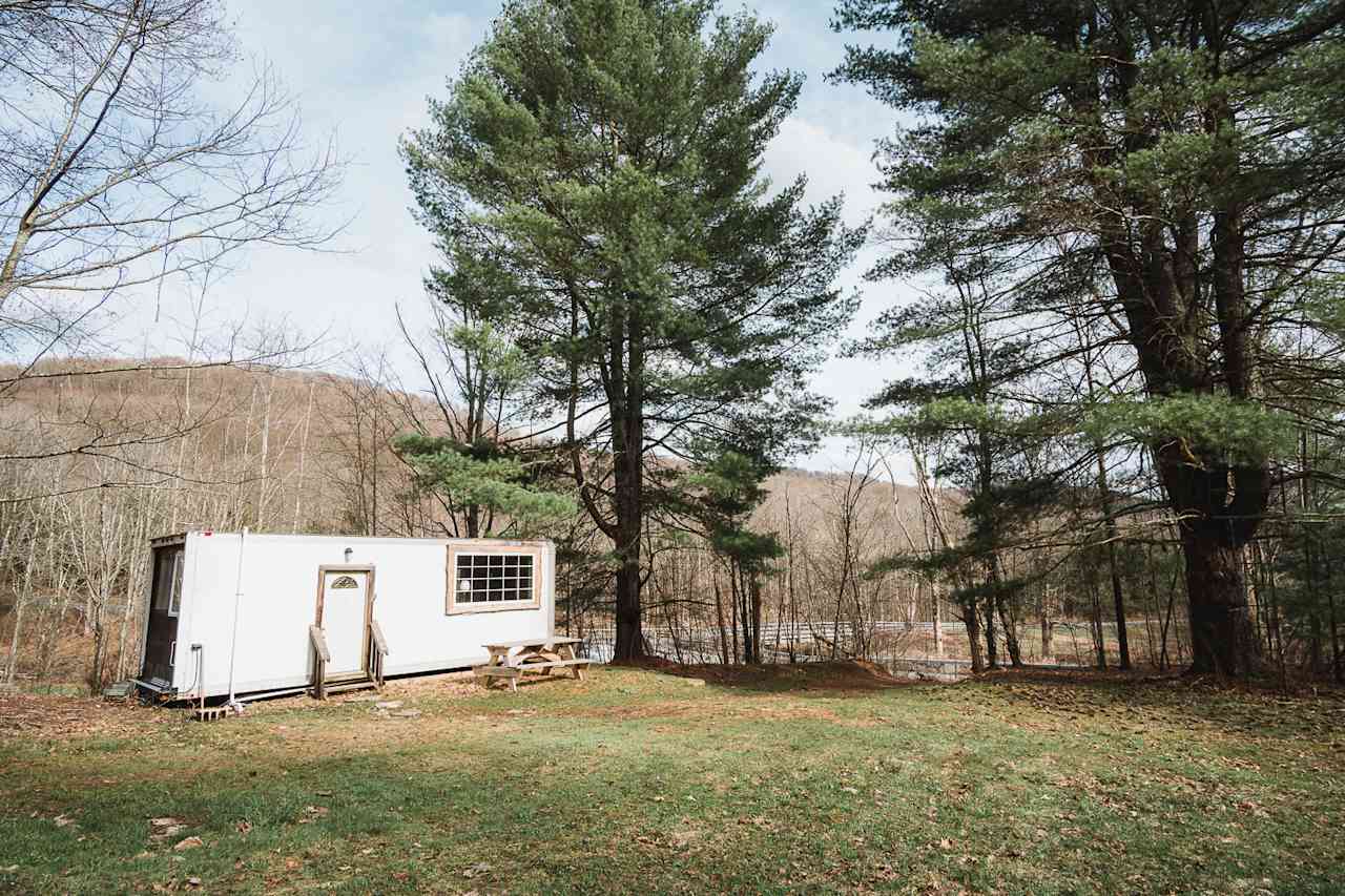 The Ravens Nest is a re-purposed box truck with electric and hot water. The truck has bunk-beds, a kitchenette (with sink, stove, coffee maker, propane grill), breakfast bar, living area, and deck. 