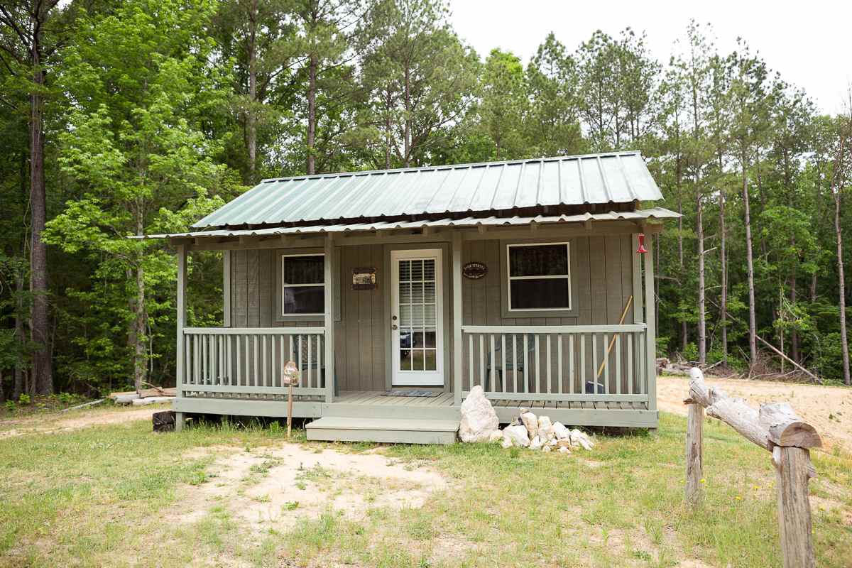 Tiny cabin, set in front of the trees.